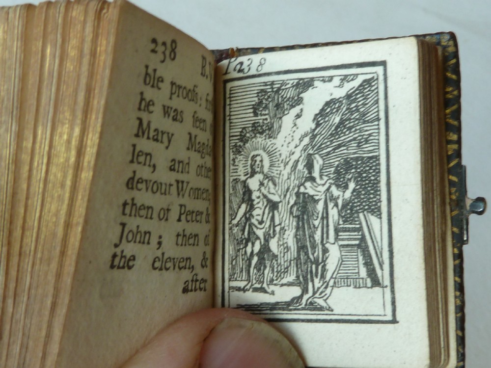 An 18th-century miniature leather-bound thumb bible featuring embossed acorn motifs and a metal clasp closure. View IX
