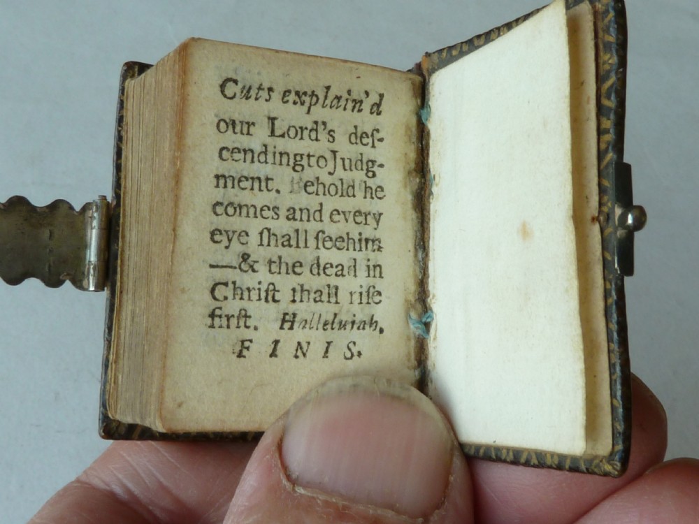An 18th-century miniature leather-bound thumb bible featuring embossed acorn motifs and a metal clasp closure. View X