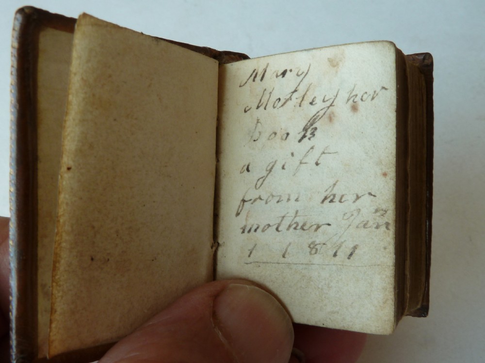An eighteenth-century dark brown calfskin leather miniature bible with visible spine wear and raised bands. View III