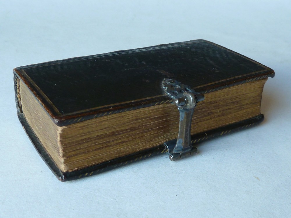 An eighteenth-century miniature Dutch leather-bound psalm book with gilt page edges and a silver metal clasp closure.