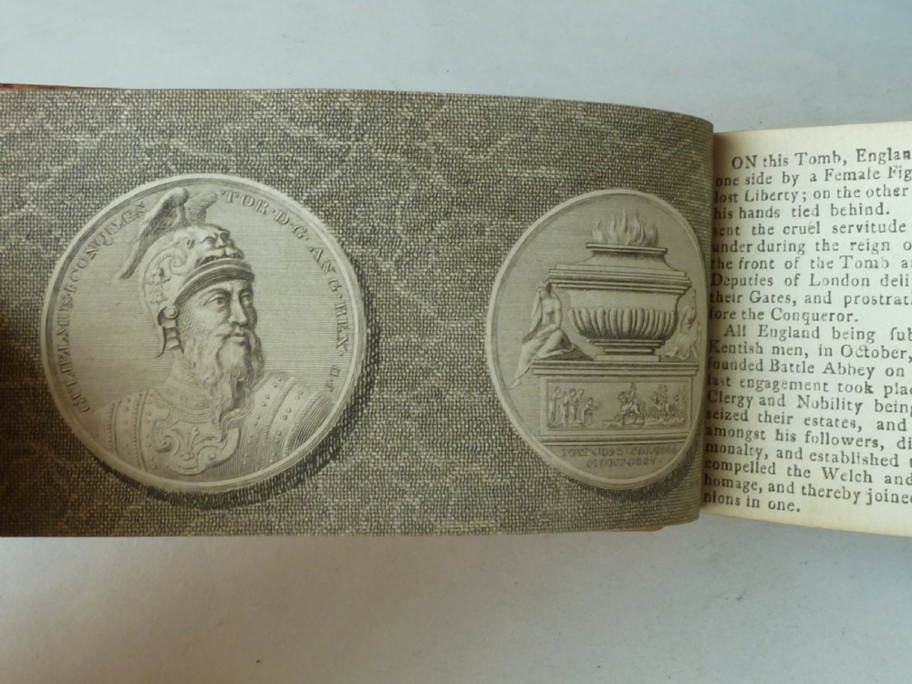 A small antique leatherbound book with a brown calfskin cover featuring gilt border tooling and aged paper edges. View VI