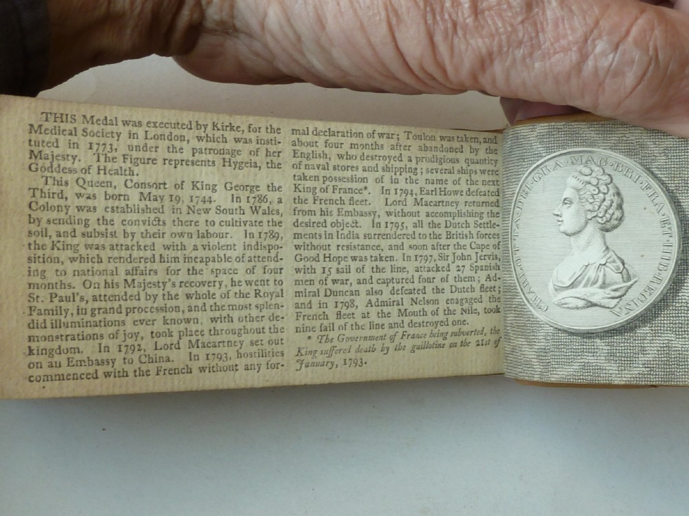 A small antique leatherbound book with a brown calfskin cover featuring gilt border tooling and aged paper edges. View VIII
