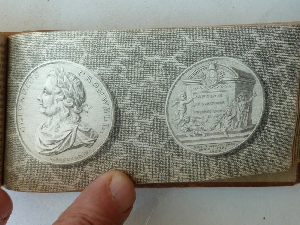 A small antique leatherbound book with a brown calfskin cover featuring gilt border tooling and aged paper edges. View IX