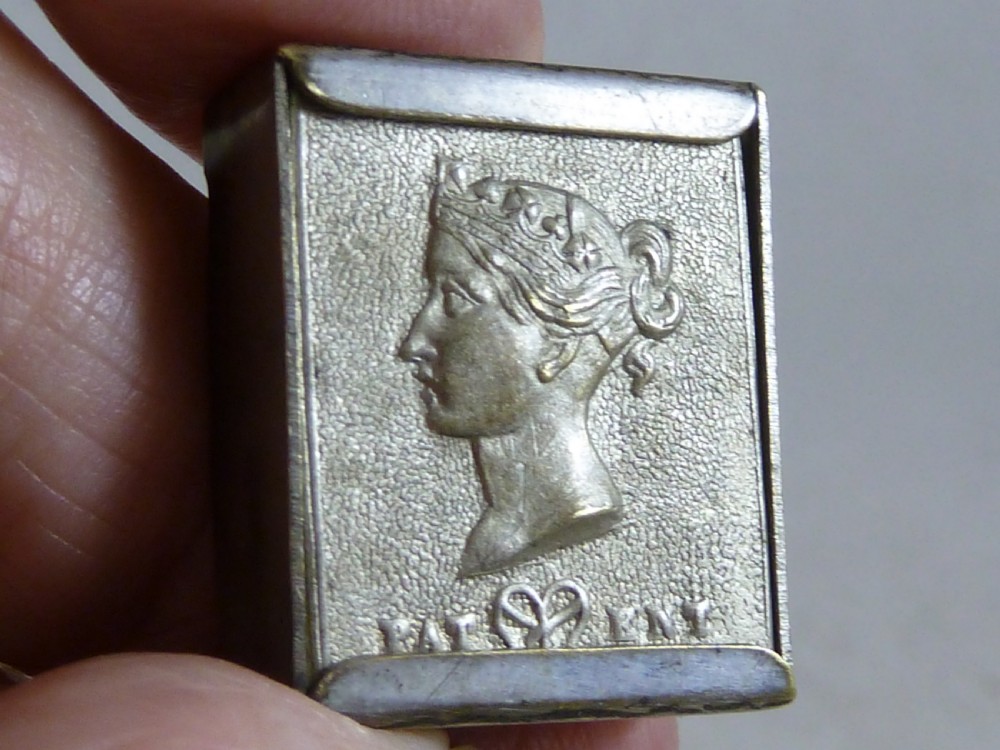 A small rectangular silver-plated stamp box featuring an embossed relief portrait of Queen Victoria in profile on the lid. View V