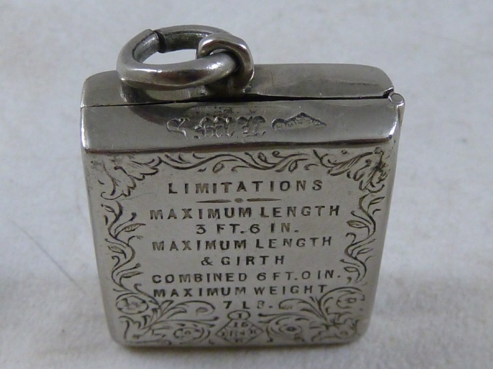 A rectangular Victorian silver-coloured metal stamp case fob featuring engraved scrollwork borders and etched text displaying inland parcel post rates. View IV