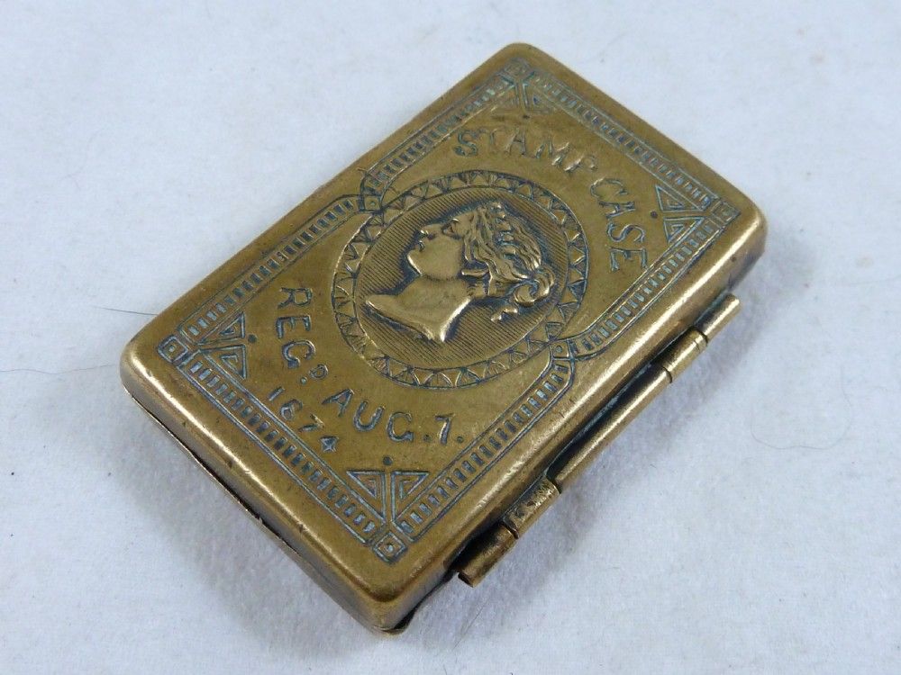 A small rectangular Victorian brass pocket stamp case embossed with a portrait of Queen Victoria and registration text dated 1874. View II