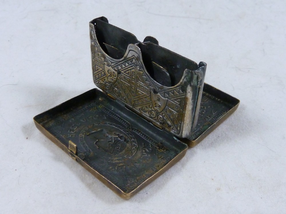A small rectangular Victorian brass pocket stamp case embossed with a portrait of Queen Victoria and registration text dated 1874. View IV
