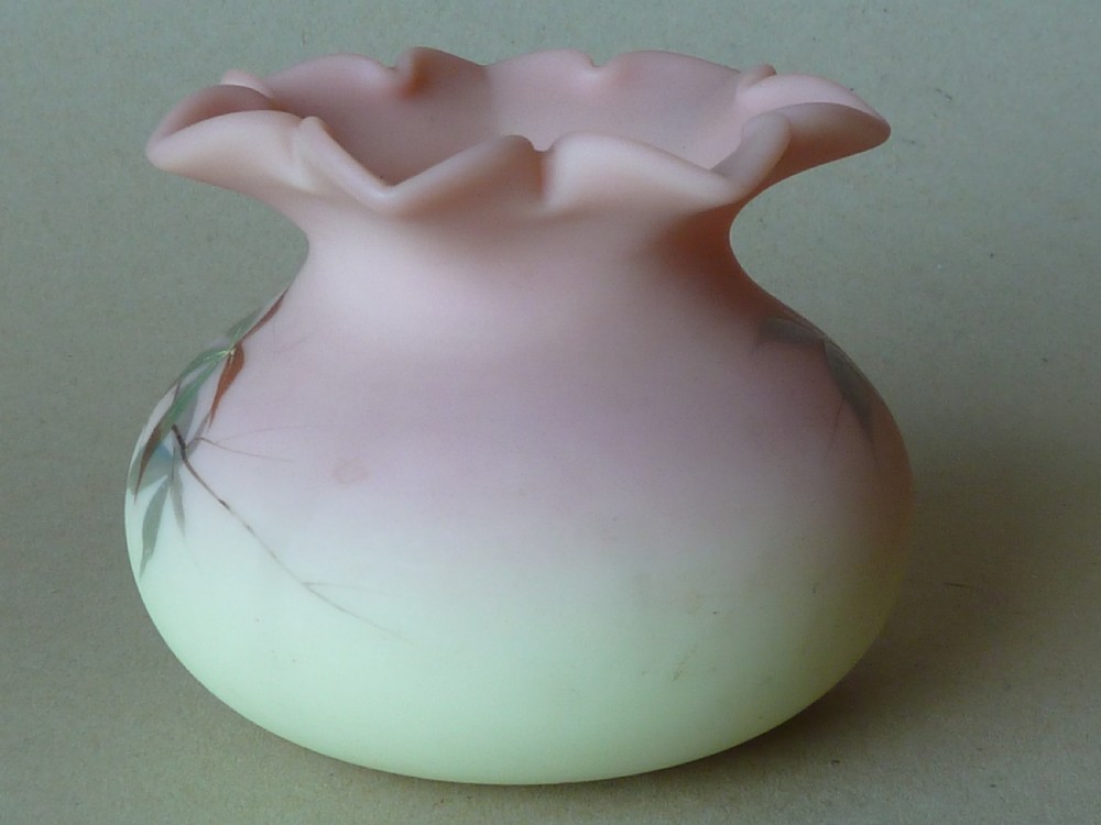A small Victorian Burmese satin glass vase with a crimped rim, shading from yellow at the base to pink at the top, decorated with hand-painted leaves and berries. View IV
