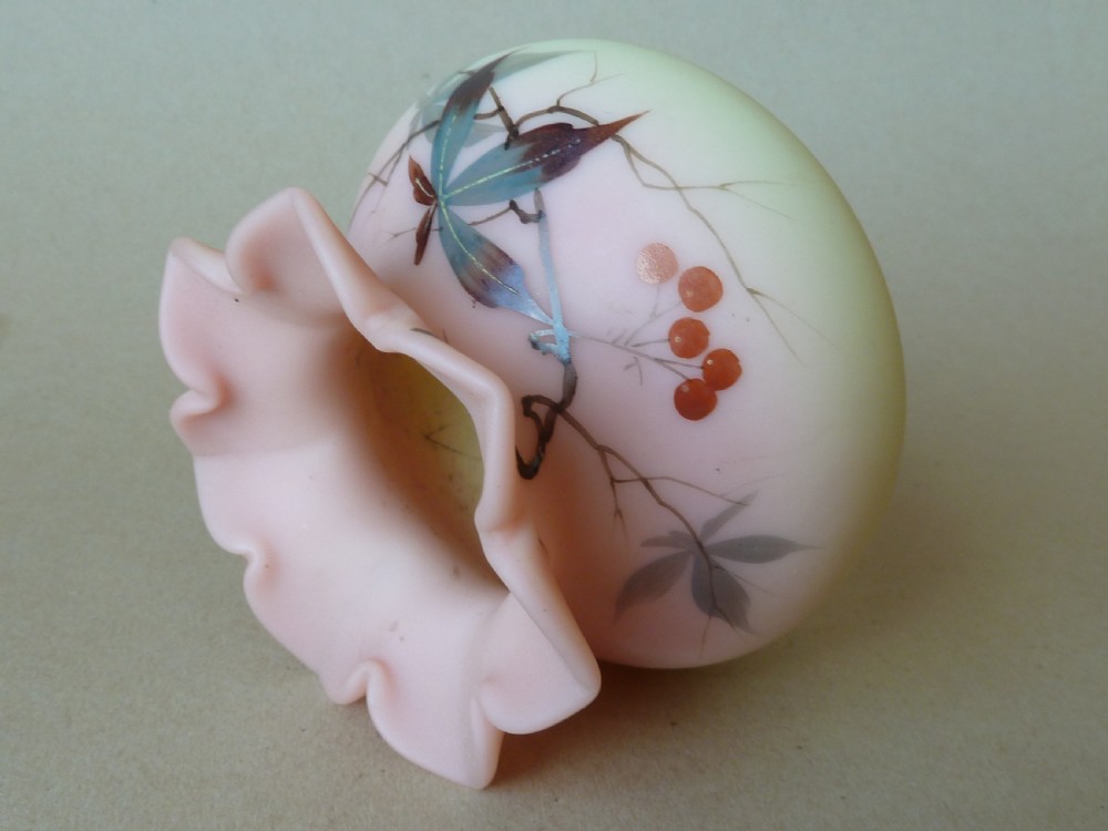 A small Victorian Burmese satin glass vase with a crimped rim, shading from yellow at the base to pink at the top, decorated with hand-painted leaves and berries. View VII