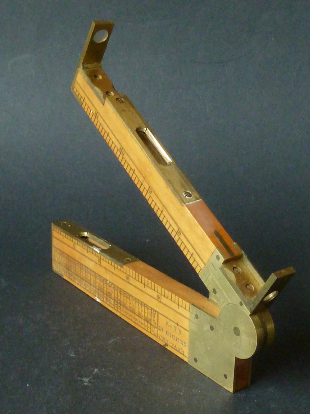 An antique boxwood and brass folding clinometer rule featuring an integrated magnetic compass, spirit level, folding sight vanes, and engraved measurement scales. View II