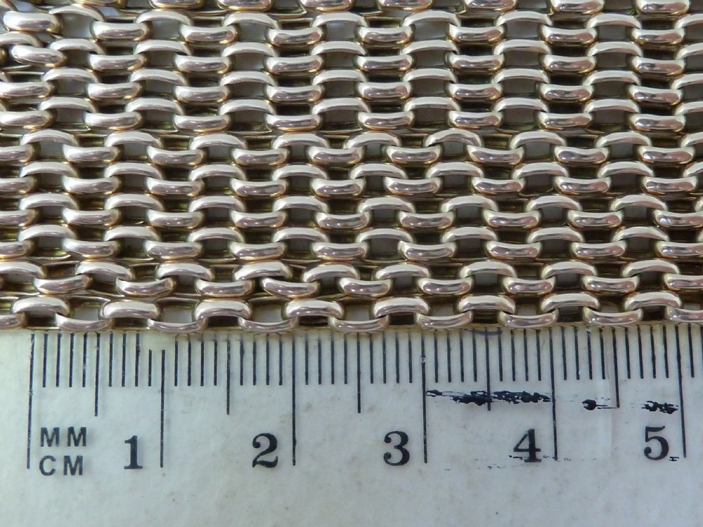 A long 14ct yellow gold Victorian guard chain featuring interlocking oval links and a dog clip clasp, laid flat against a neutral surface. View V