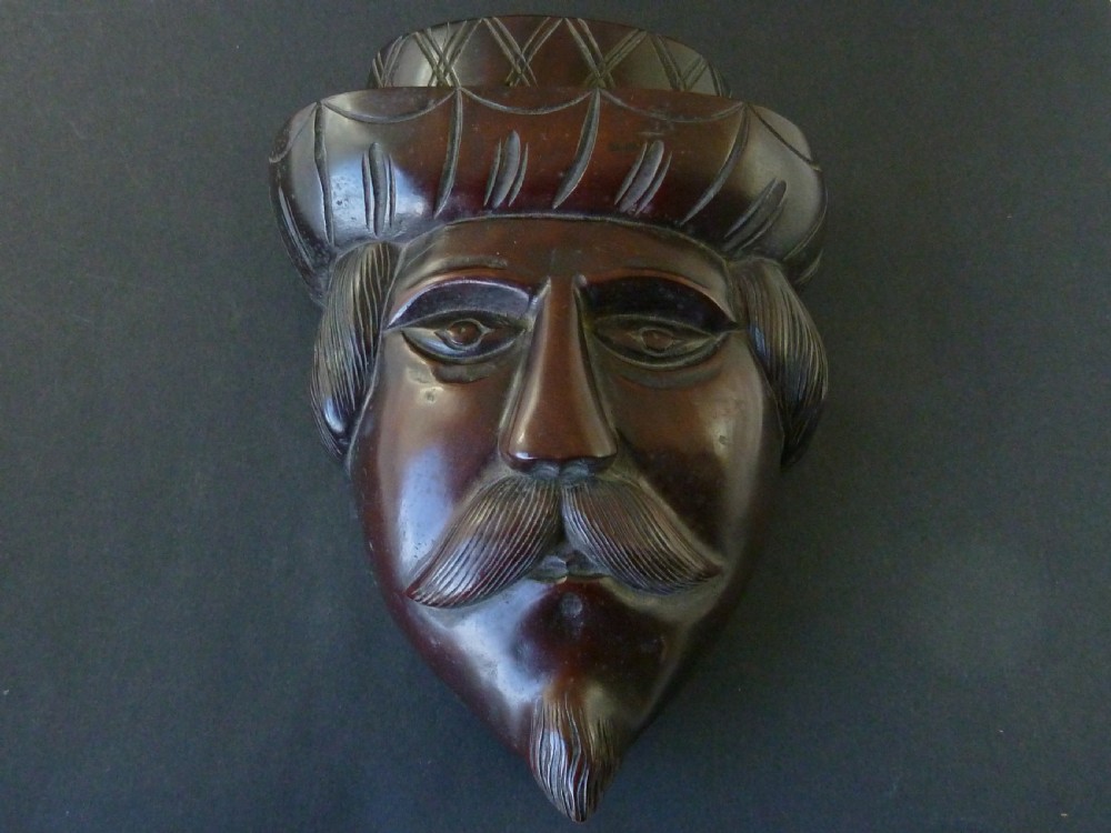 A polished dark hardwood wall mask depicting a turbaned man with a detailed moustache and beard. View II