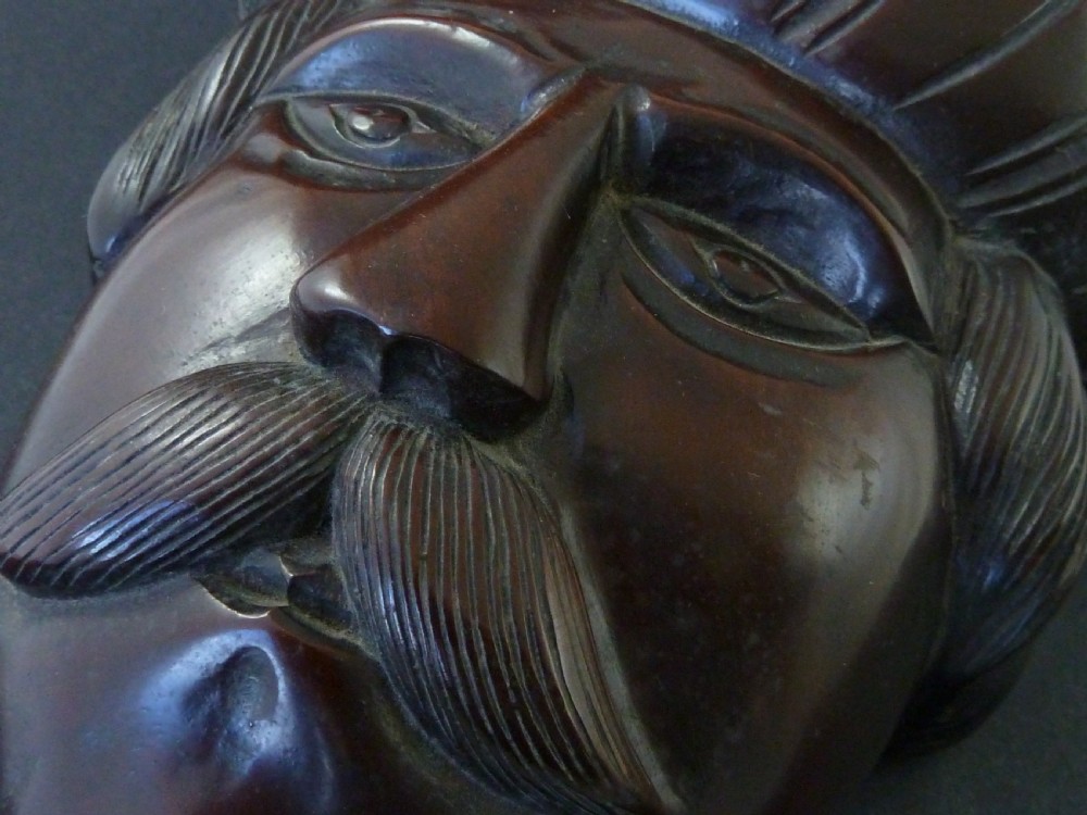 A polished dark hardwood wall mask depicting a turbaned man with a detailed moustache and beard. View IV