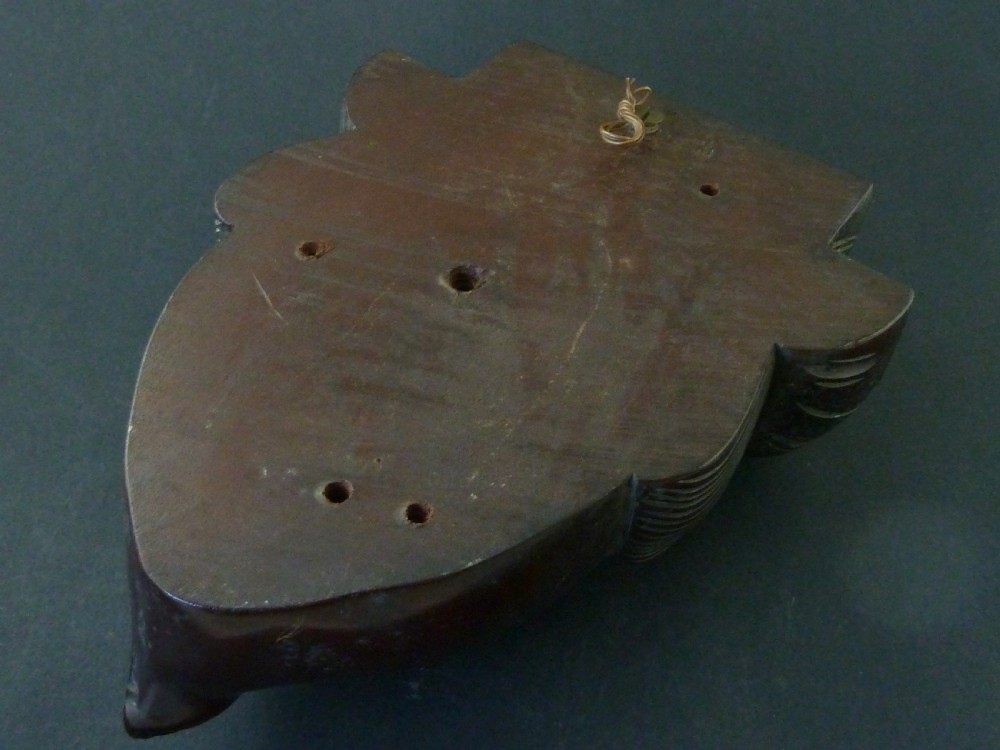 A polished dark hardwood wall mask depicting a turbaned man with a detailed moustache and beard. View V