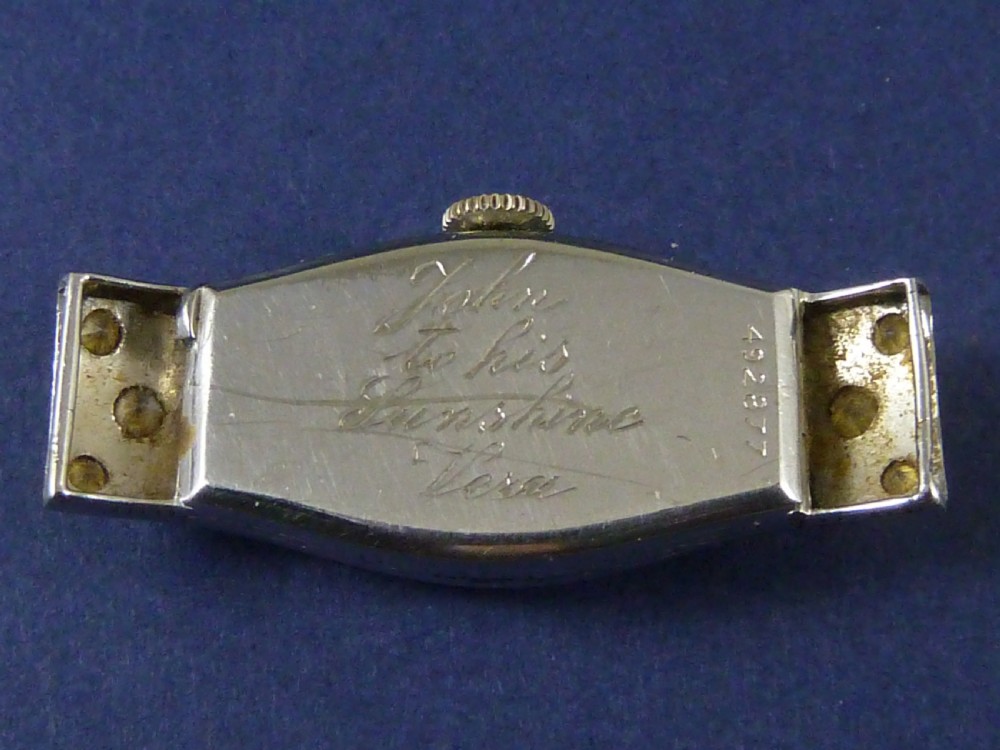 An Art Deco ladies cocktail watch with a white gold diamond-set geometric case, a cream dial, and a brown textured leather strap. View VIII