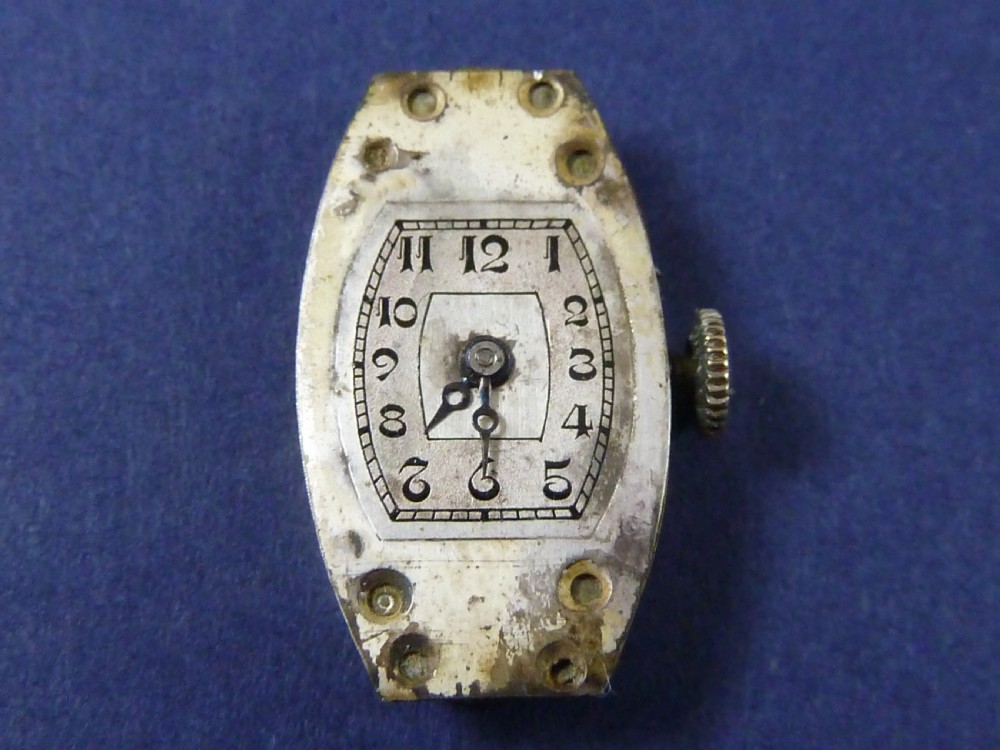 An Art Deco ladies cocktail watch with a white gold diamond-set geometric case, a cream dial, and a brown textured leather strap. View XI