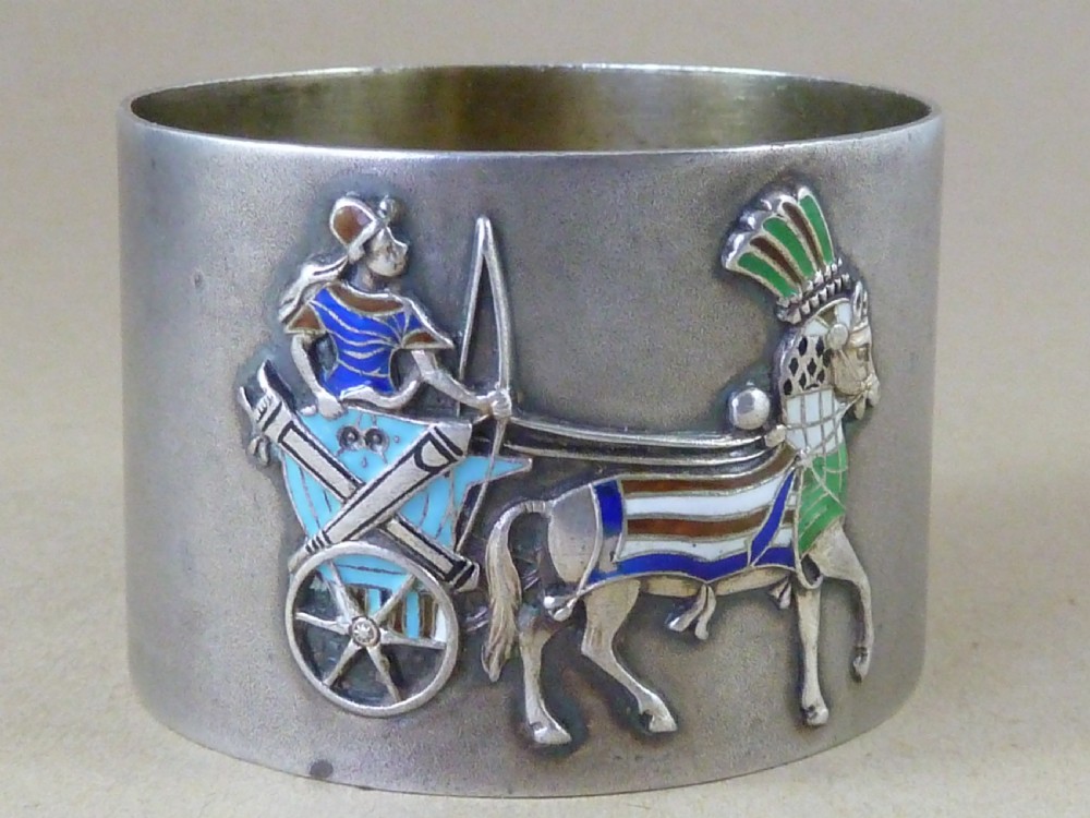 A curved 800 silver napkin ring featuring a detailed enamel relief depiction of a charioteer driving a horse in blue and green tones. View V