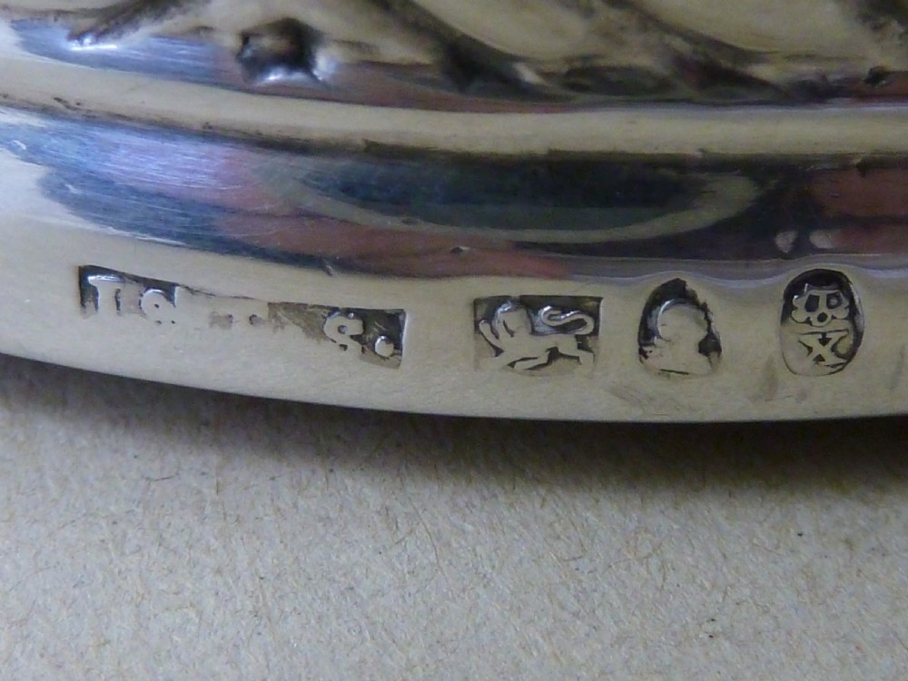 A pair of round Georgian sterling silver wine coasters with gadrooned rims, turned wooden bases, and central engraved silver bosses. View VII