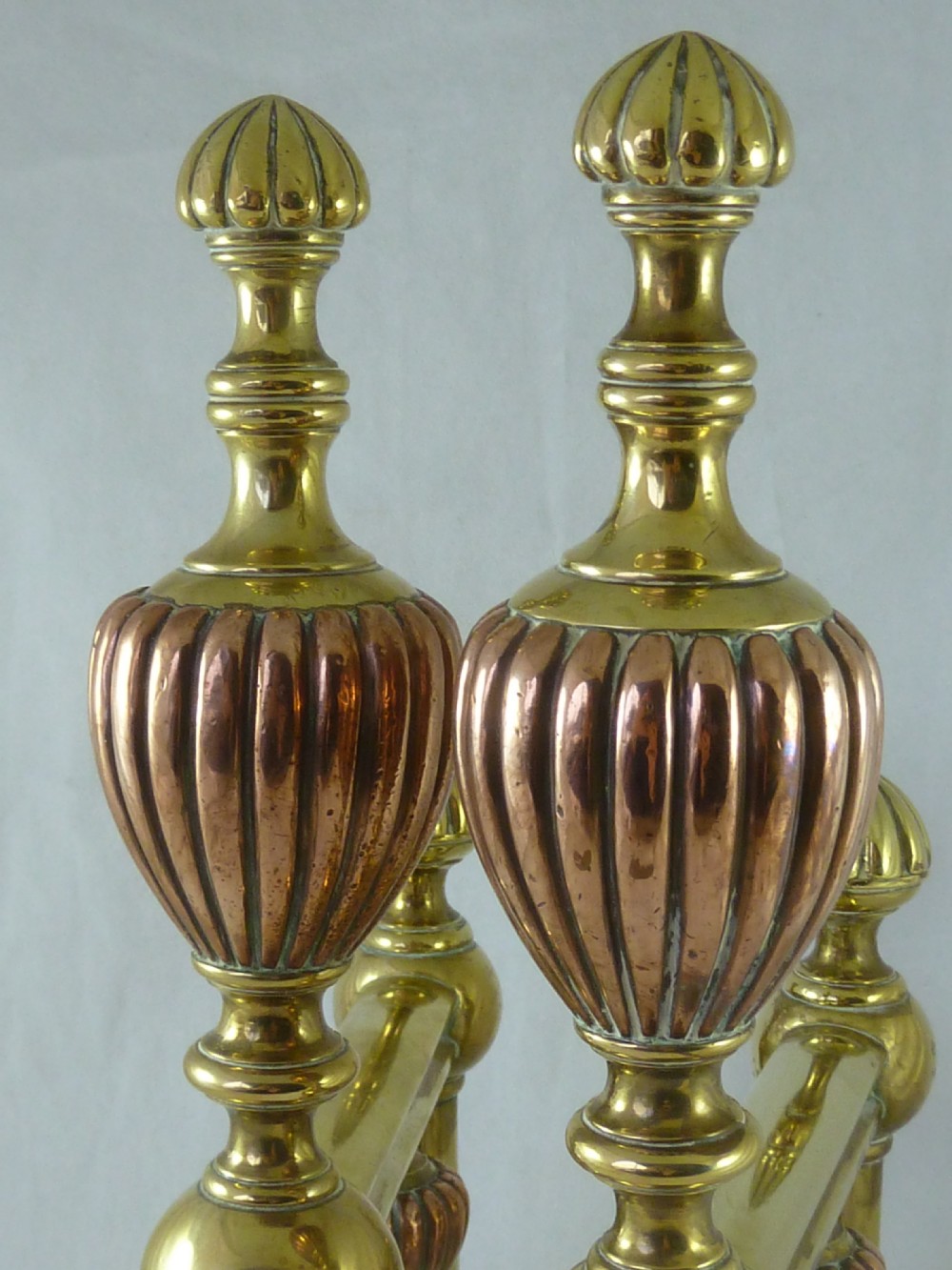 A pair of Victorian brass and copper fire dogs featuring ribbed urn-shaped finials, turned posts, and claw feet. View VII