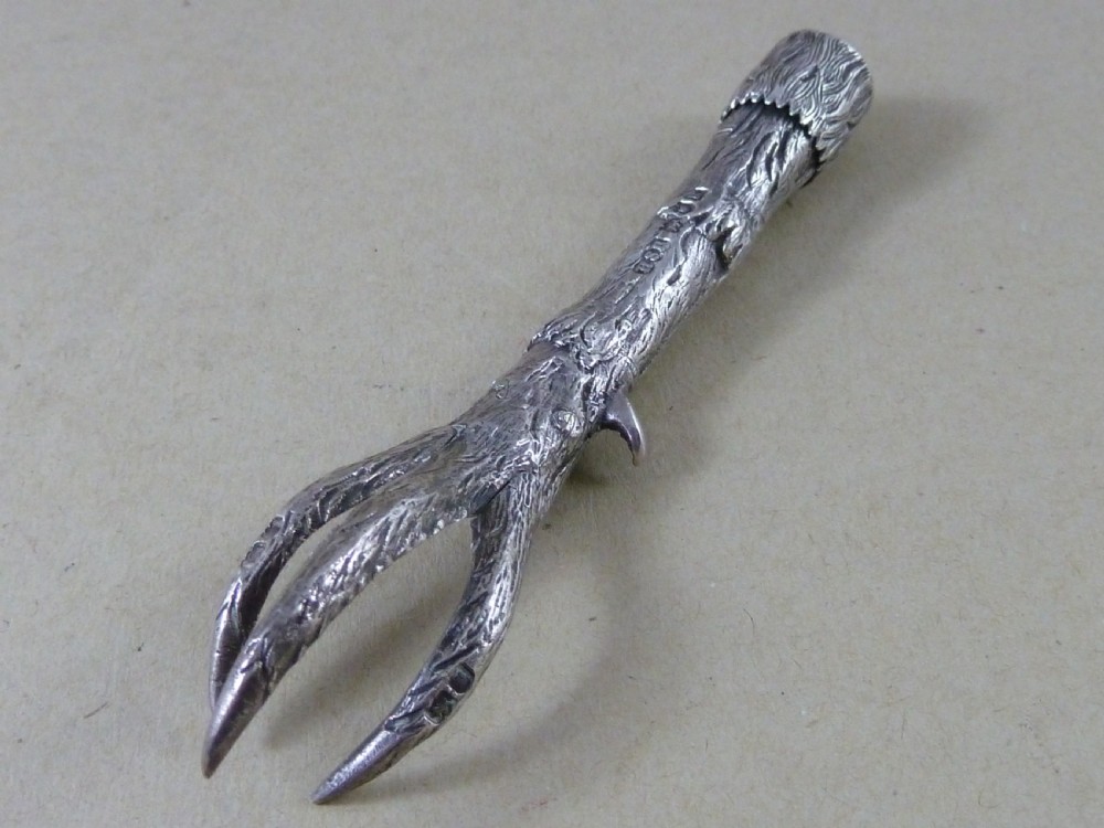 A hallmarked sterling silver sugar tongs crafted in the detailed shape of an articulated eagle claw.