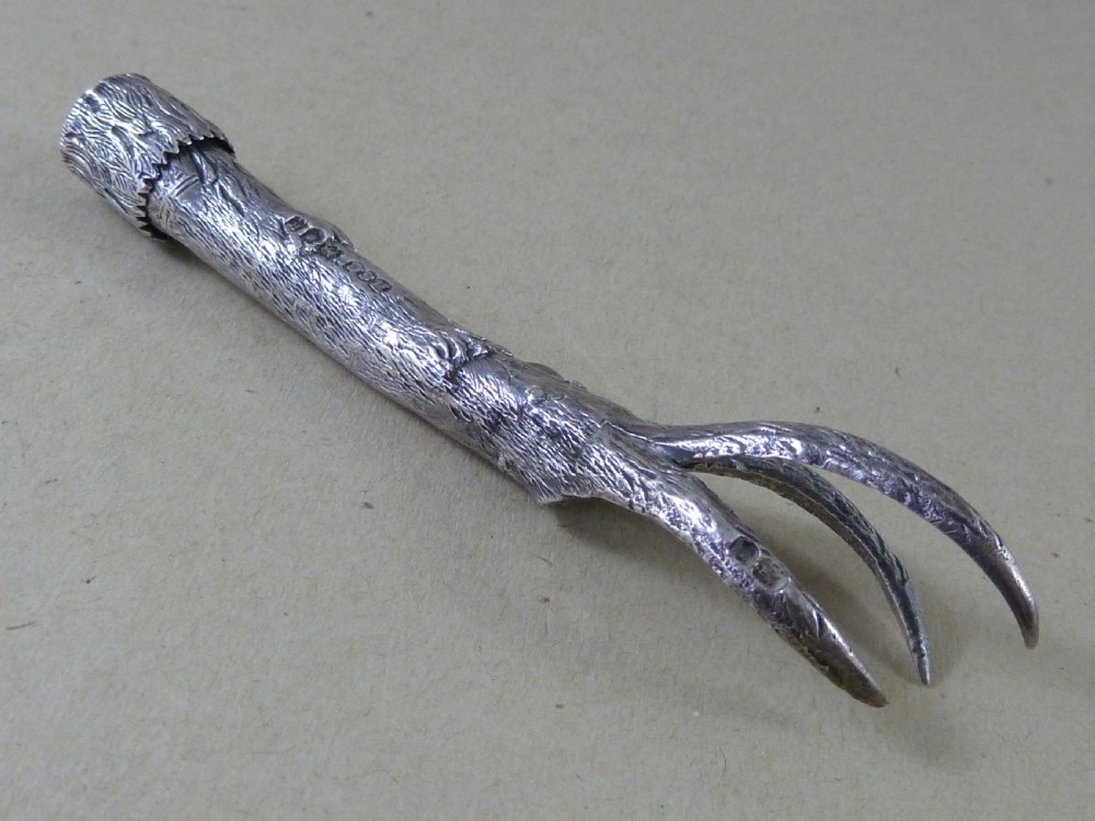 A hallmarked sterling silver sugar tongs crafted in the detailed shape of an articulated eagle claw. View II