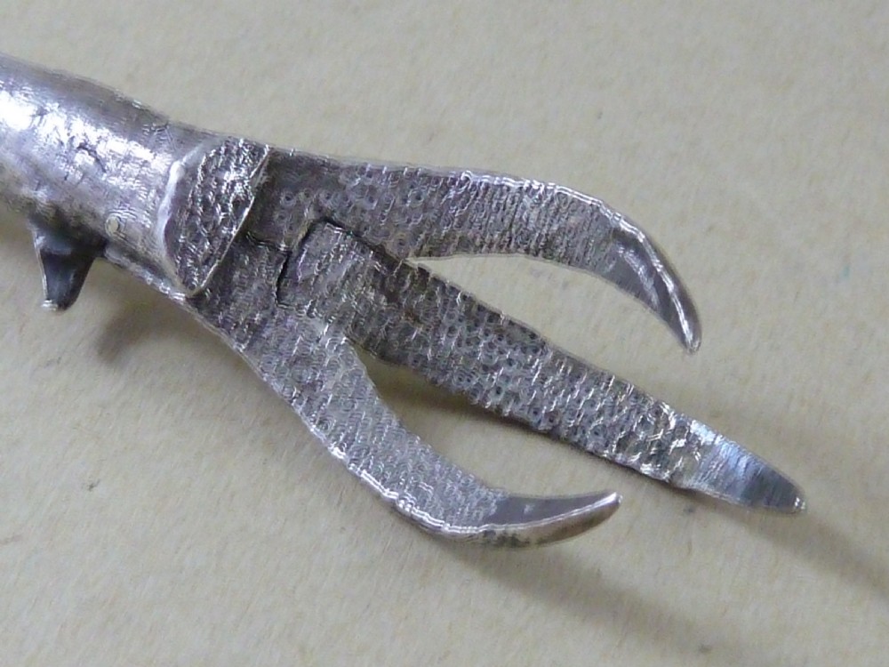A hallmarked sterling silver sugar tongs crafted in the detailed shape of an articulated eagle claw. View VI