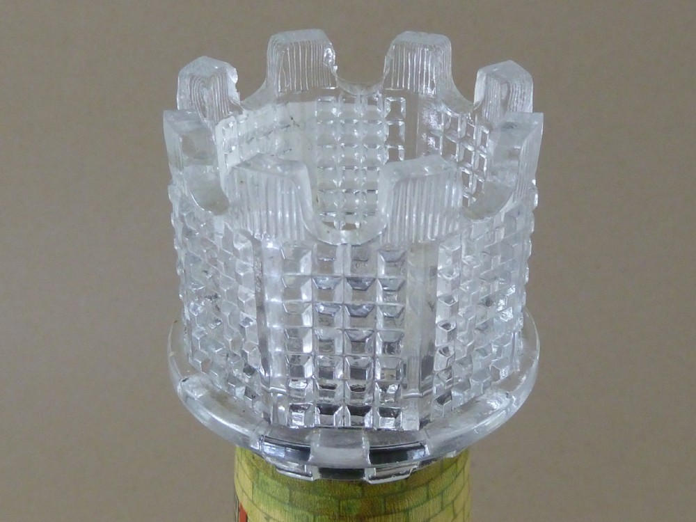 A Victorian lithographed tin candle holder shaped like a lighthouse with a clear pressed glass lantern shade. View VII