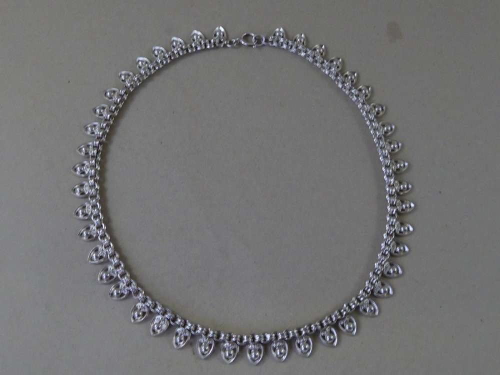 An Edwardian sterling silver collar necklace featuring a round link chain suspended with pierced heart-shaped fringe pendants. View IV