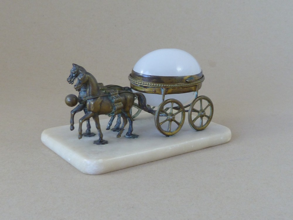 A French Palais Royal style miniature horse-drawn carriage featuring a white opaline glass egg-shaped casket mounted on a gilt metal frame and alabaster base.