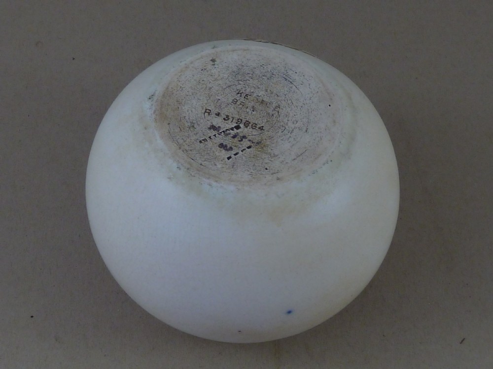 A spherical cream ceramic match striker featuring a sepia transfer print of cricketer W.G. Grace holding a bat within a scrollwork frame. View IV