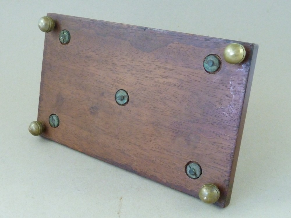 An antique brass letter rack shaped as miniature cricket bats, wickets, and a ball mounted on a rectangular mahogany wooden base with small bun feet. View VI