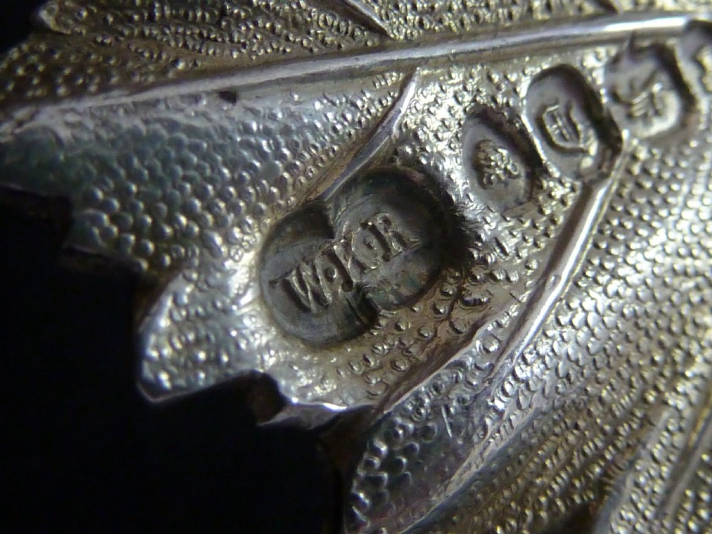 A Victorian sterling silver decanter label shaped as a vine leaf, pierced with the word PORT and attached to a metal suspension chain. View V