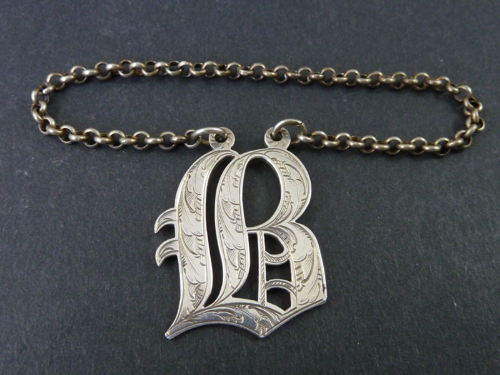Victorian solid silver decanter label formed as an engraved cut-out monogram letter with a silver suspension chain.