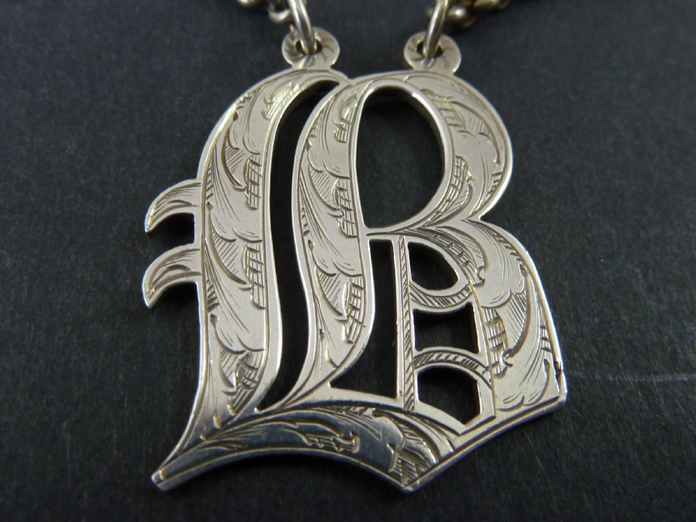 Victorian solid silver decanter label formed as an engraved cut-out monogram letter with a silver suspension chain. View III