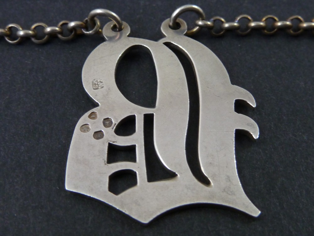 Victorian solid silver decanter label formed as an engraved cut-out monogram letter with a silver suspension chain. View IV