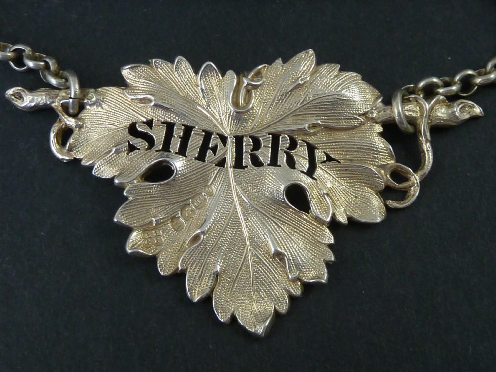 A George IV sterling silver decanter label shaped as a detailed vine leaf with pierced lettering reading SHERRY and attached suspension chain. View II