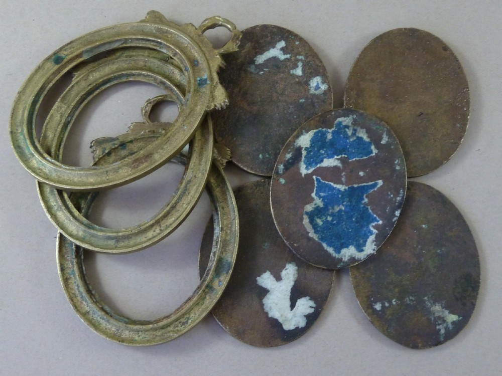 A set of five dark bronze oval portrait medallions depicting historical figures, alongside decorative cast brass frames with bow motifs. View II