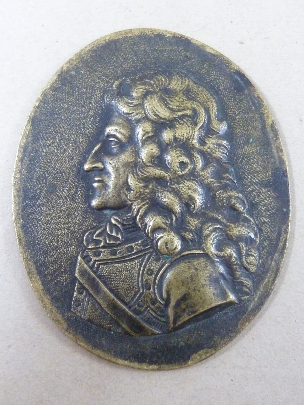 A set of five dark bronze oval portrait medallions depicting historical figures, alongside decorative cast brass frames with bow motifs. View III
