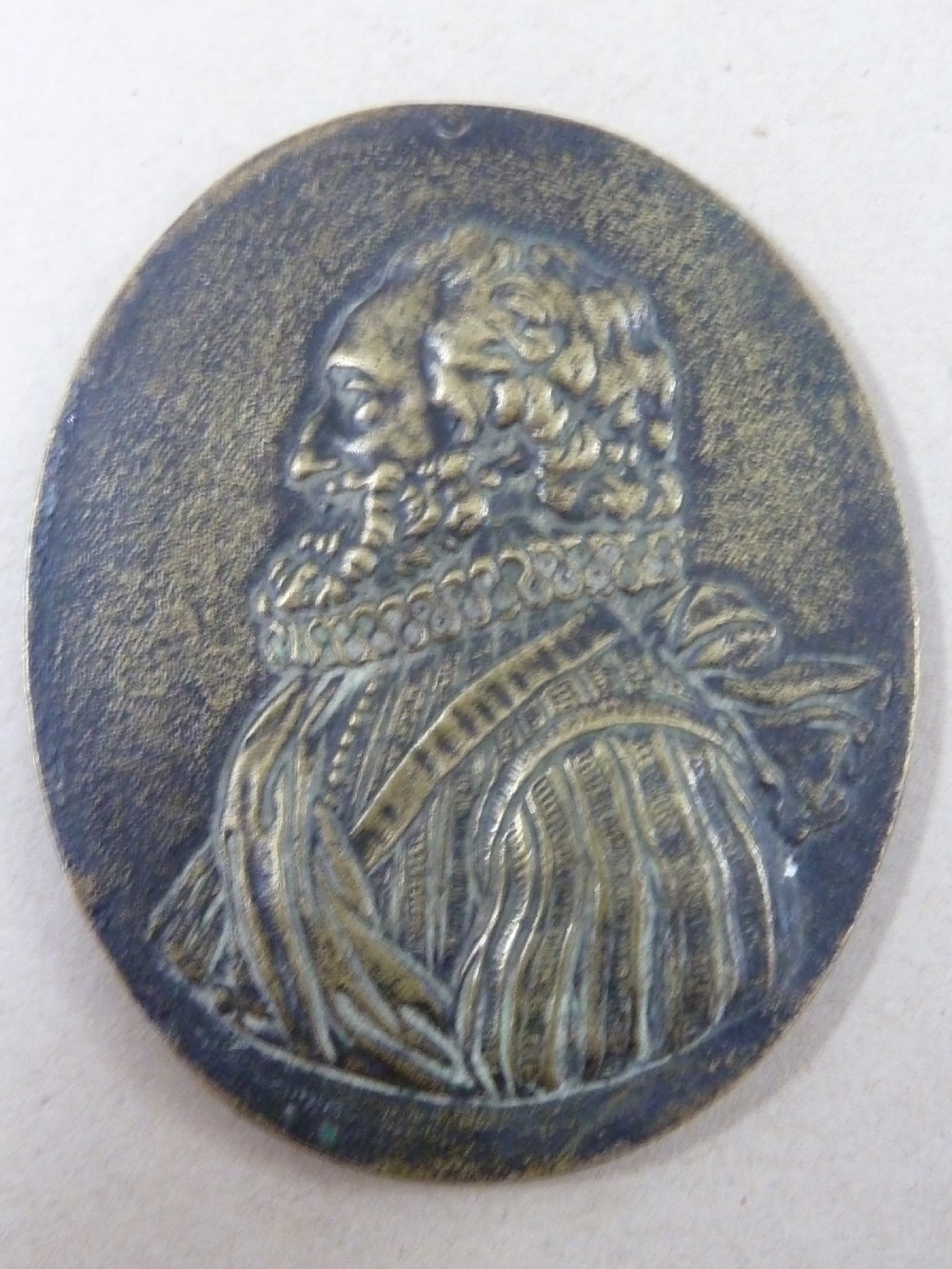 A set of five dark bronze oval portrait medallions depicting historical figures, alongside decorative cast brass frames with bow motifs. View IV