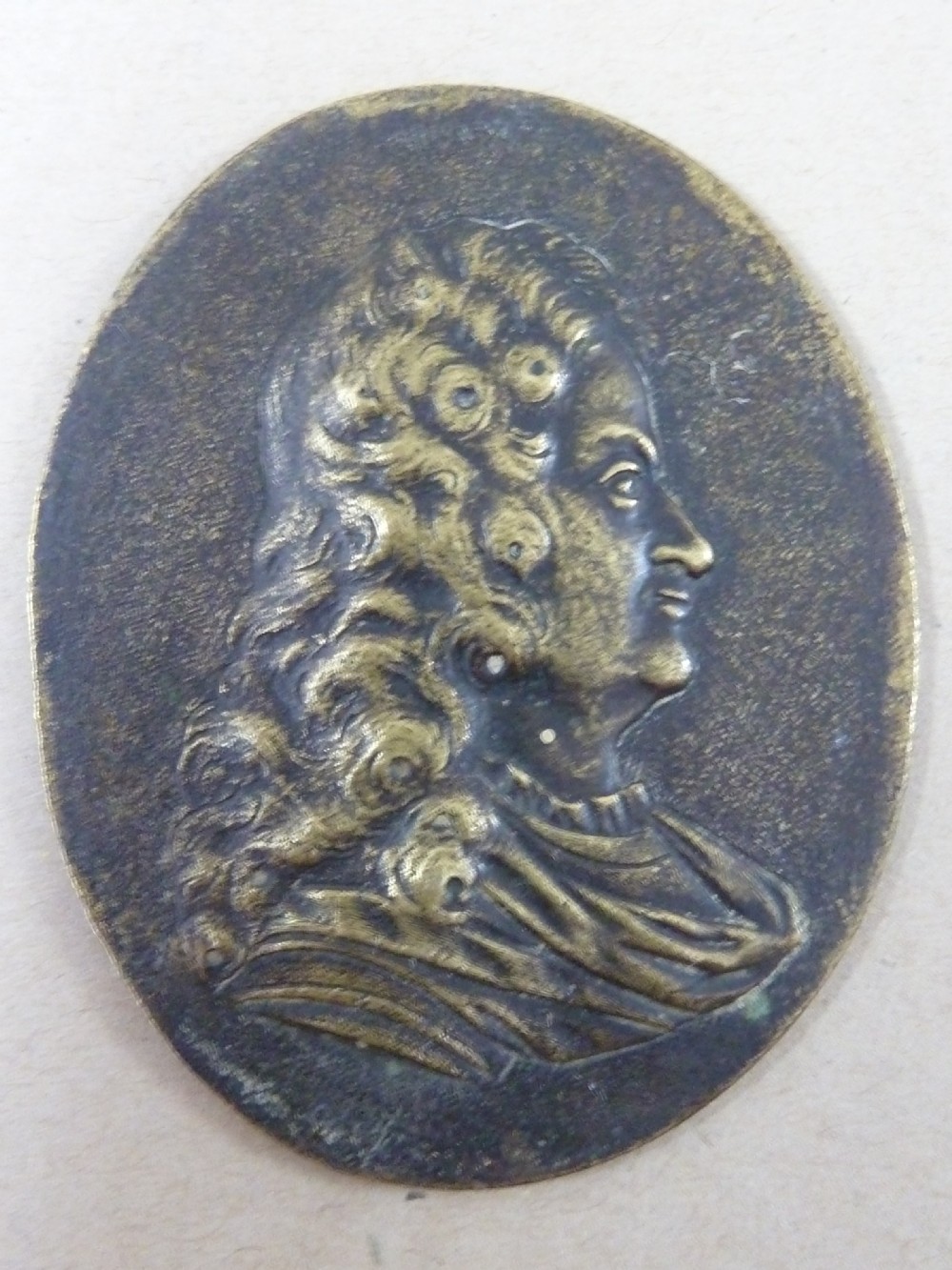 A set of five dark bronze oval portrait medallions depicting historical figures, alongside decorative cast brass frames with bow motifs. View VII