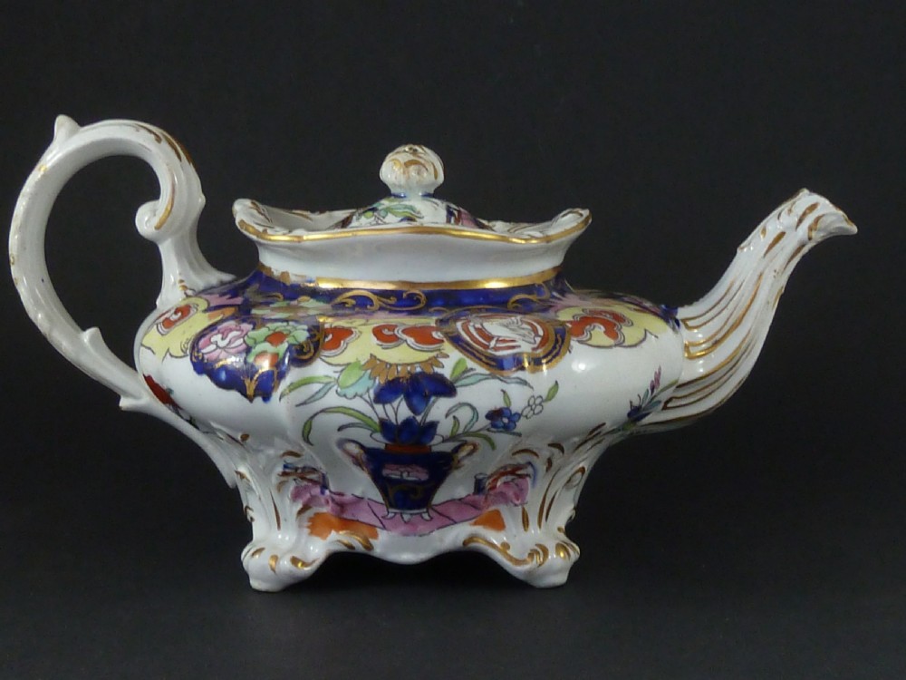 A Masons ironstone tea set featuring a teapot, milk jug, and teacup with saucer in cobalt blue, pink, and yellow enamelling with gilded details. View II