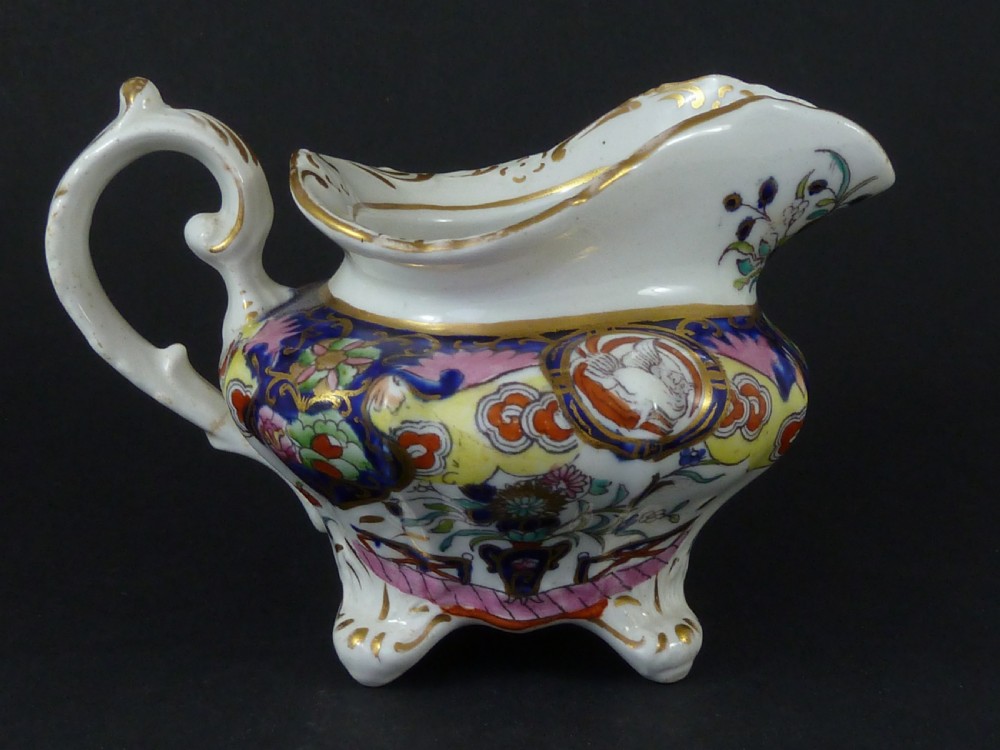 A Masons ironstone tea set featuring a teapot, milk jug, and teacup with saucer in cobalt blue, pink, and yellow enamelling with gilded details. View VI