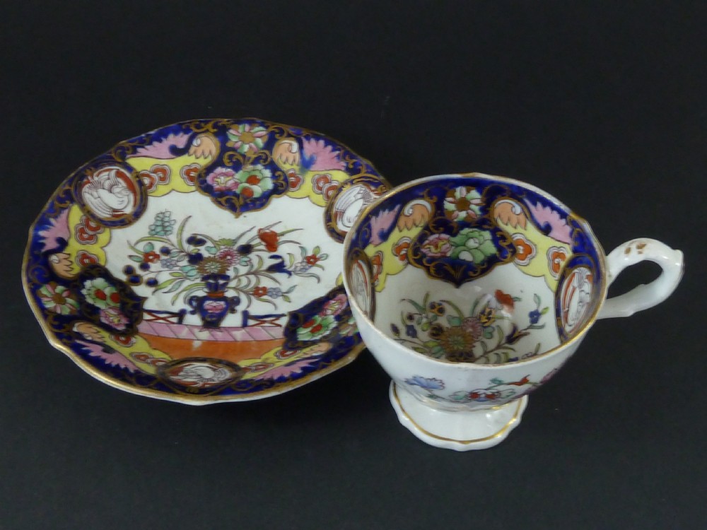 A Masons ironstone tea set featuring a teapot, milk jug, and teacup with saucer in cobalt blue, pink, and yellow enamelling with gilded details. View VII
