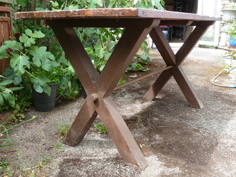 A rustic painted pine tavern table featuring an X-frame trestle base, an iron stretcher rod, and a weathered two-plank top with cleated ends. View III