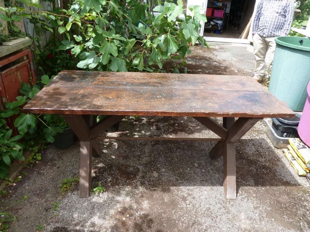 A rustic painted pine tavern table featuring an X-frame trestle base, an iron stretcher rod, and a weathered two-plank top with cleated ends. View V