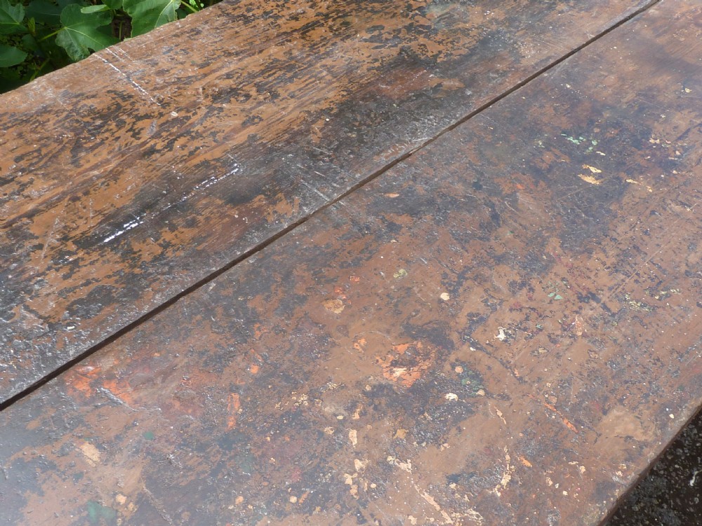 A rustic painted pine tavern table featuring an X-frame trestle base, an iron stretcher rod, and a weathered two-plank top with cleated ends. View VIII