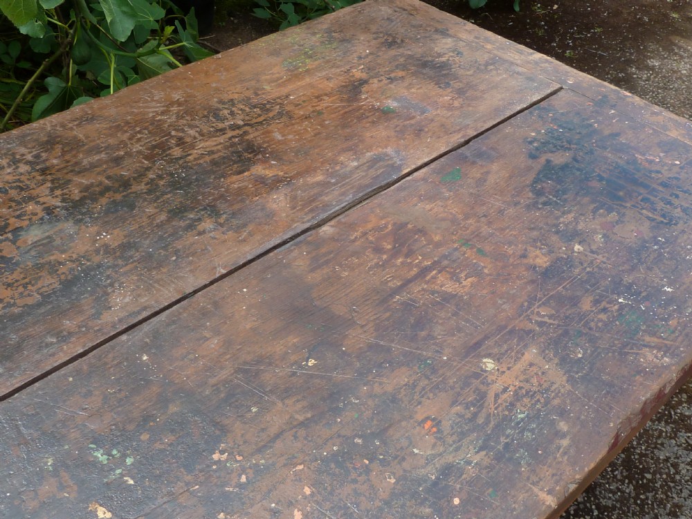 A rustic painted pine tavern table featuring an X-frame trestle base, an iron stretcher rod, and a weathered two-plank top with cleated ends. View IX