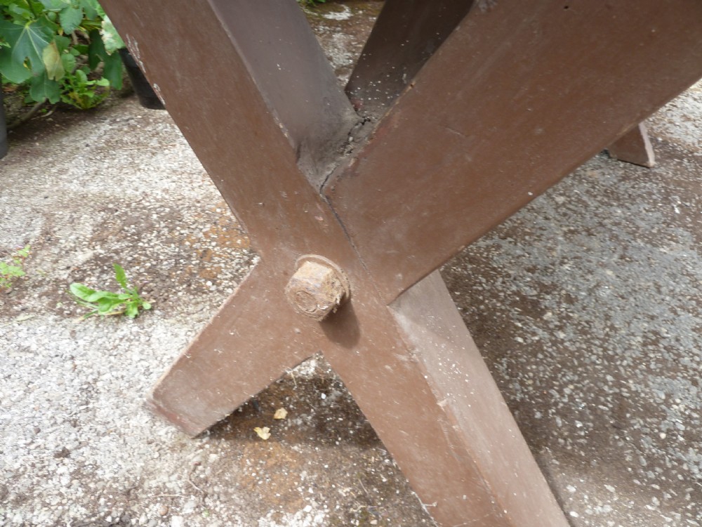A rustic painted pine tavern table featuring an X-frame trestle base, an iron stretcher rod, and a weathered two-plank top with cleated ends. View XVI
