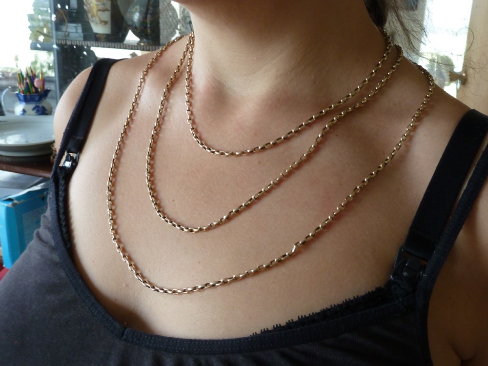 A long 14ct yellow gold Victorian guard chain featuring interlocking oval links and a dog clip clasp, laid flat against a neutral surface. View VIII