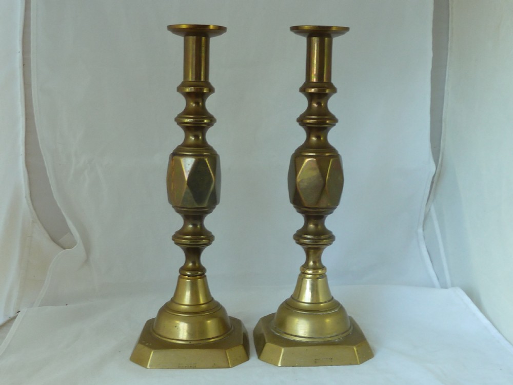 A pair of 14-inch Victorian cast brass candlesticks featuring faceted diamond-shaped centre knops and octagonal stepped bases.